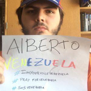 Alberto Alfonzo holds a #SOSVENEZUELA sign  in support of student protesters.