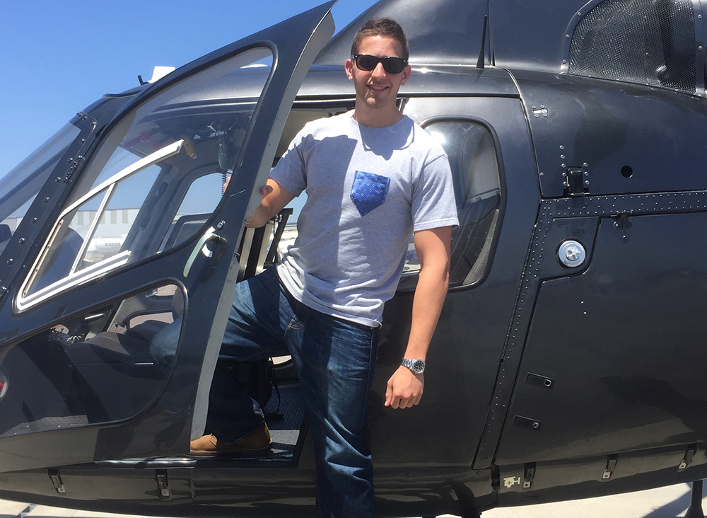 COURTESY MATTHEW ARONSON
North by South founder Matthew Aronson (COL ’15) steps out of a helicopter wearing one of his company’s T-shirts with pockets made from necktie material. The startup now boasts more than 100 different designs.