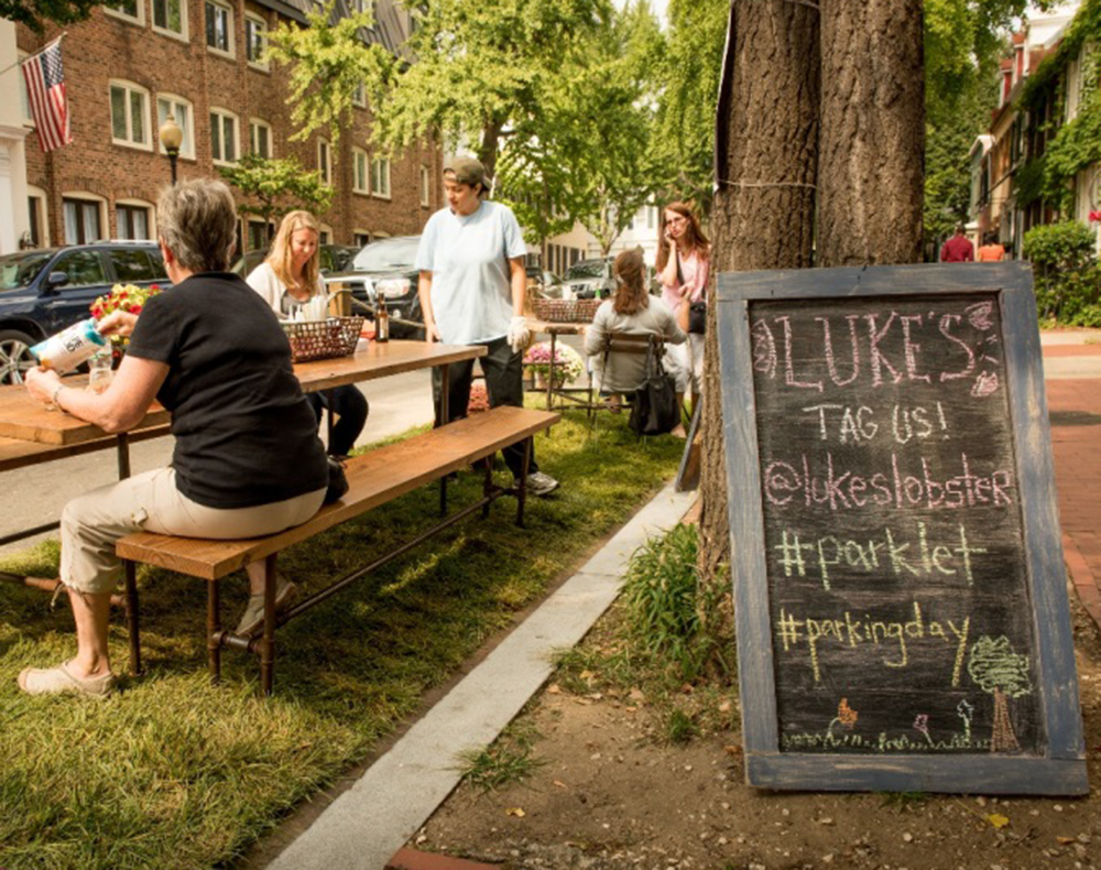 COURTESY GEORGETOWN BUSINESS IMPROVEMENT DISTRICT
Customers enjoy food outside of Luke’s Lobster at a parklet set up with tables for Park(ing) Day last year. The annual event returns to the district today with four parklets in Georgetown hosted by local businesses. 