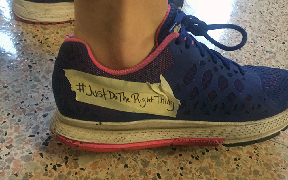 COURTESY JAKE MAXMIN
A student activist tapes over the Nike logo on a shoe to protest unethical business practices. A letter sent to University President John J. DeGioia asked the university to sever ties with the athletic apparel company.