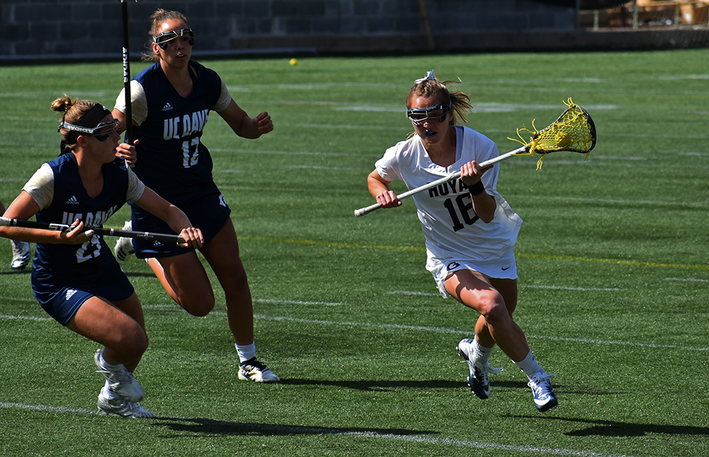 MARGARET FOUBERG/ THE HOYA | Junior attack Natalia Lynch cradles by two UC Davis Defenders on March 24. Lynch tallied 2 goals and 2 assists in the win. 