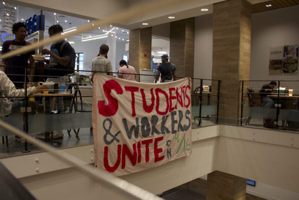 ALISON HERR/THE HOYA | Student activists from the Georgetown Solidarity Committee hung a banner in ODonovan Hall on April 10 in support of campus food service workers negotiating their labor contract with Aramark. 