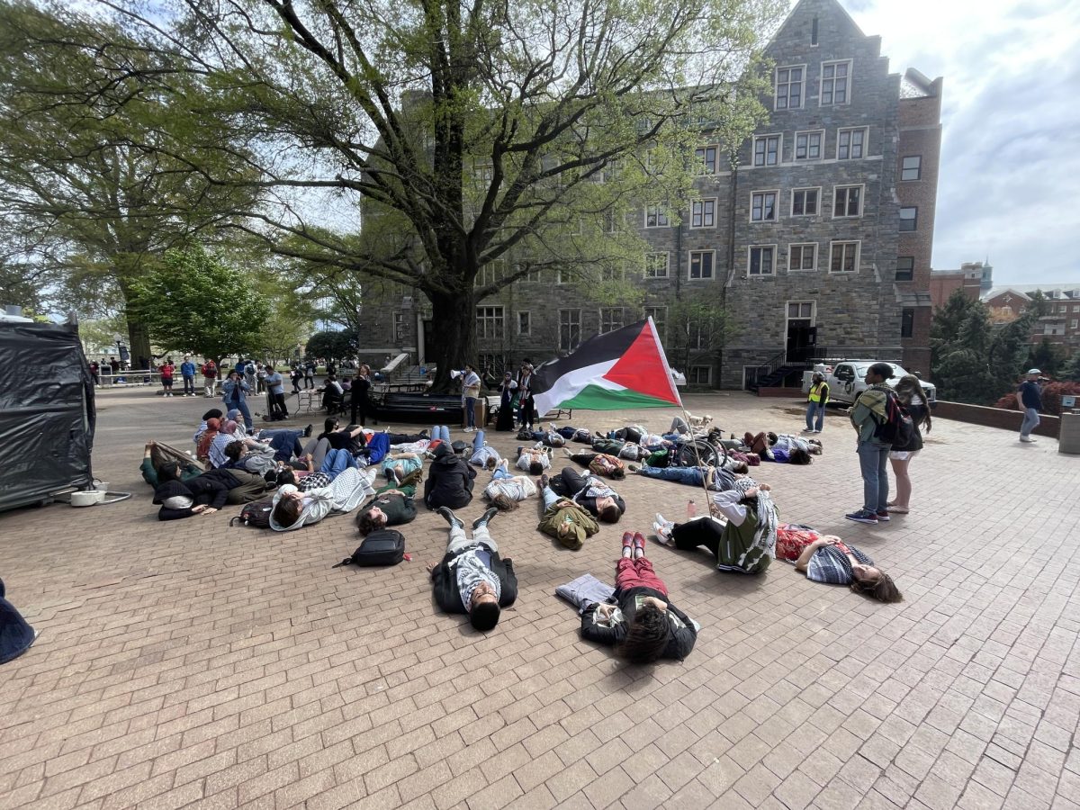 Aamir Jamil/The Hoya | Members of the Georgetown University chapter of Students for Justice in Palestine (SJP), a student group that demonstrates support for Palestinian students, organized a die-in protest in Red Square while prospective students and parents visited campus during Georgetown Admissions Ambassador Program (GAAP) Weekend on April 12, commemorating Palestinians killed in a Gazan hospital.