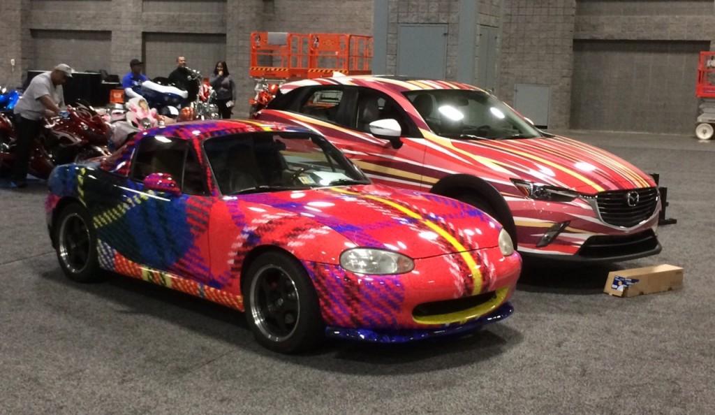 Professor L. Collier Hyams’ “Sassy Lassie” tartan Mazda Miata and Zack Engler’s (COL ’18) “Hyper” CX-3 Mazda during the Washington Auto Show setup on Wednesday, Jan. 20. The show highlights artwork from 11 Georgetown students and Hyams.